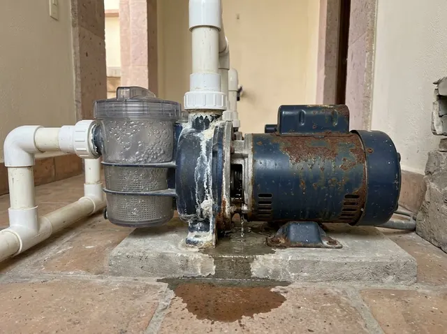 Bomba de alberca actual con óxido, goteo y un charco